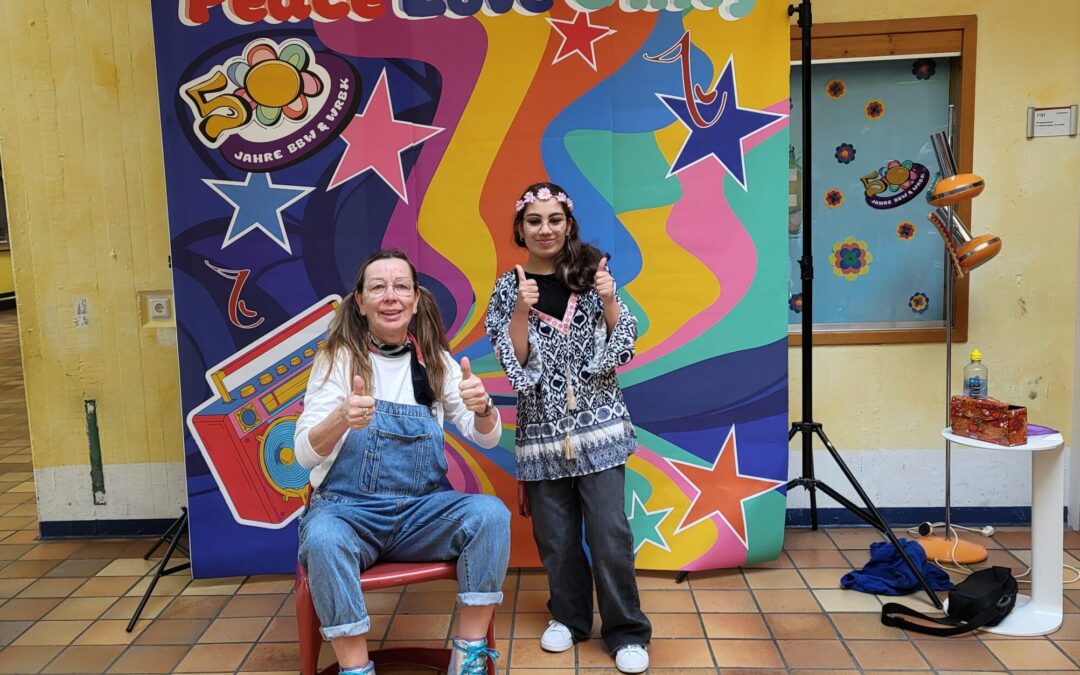 Ausbilderin Sabine Neufelder (li) und Liana Majidi vor der Fotowand im Stil der 70er Jahre.